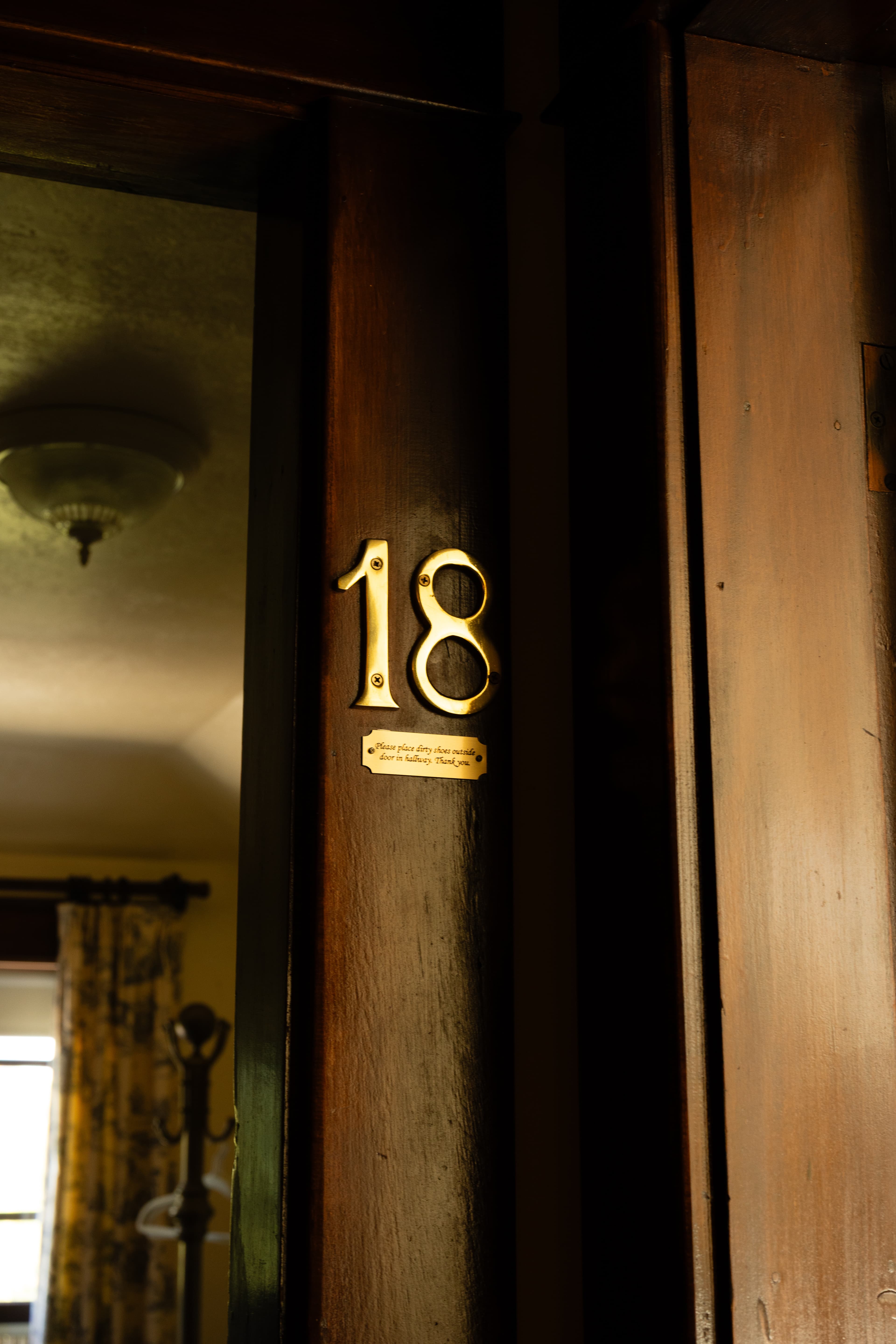 A close-up of a wooden door with the number 18 in gold lettering.